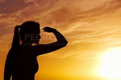 Silhouetted female looking at something interesting at sunset